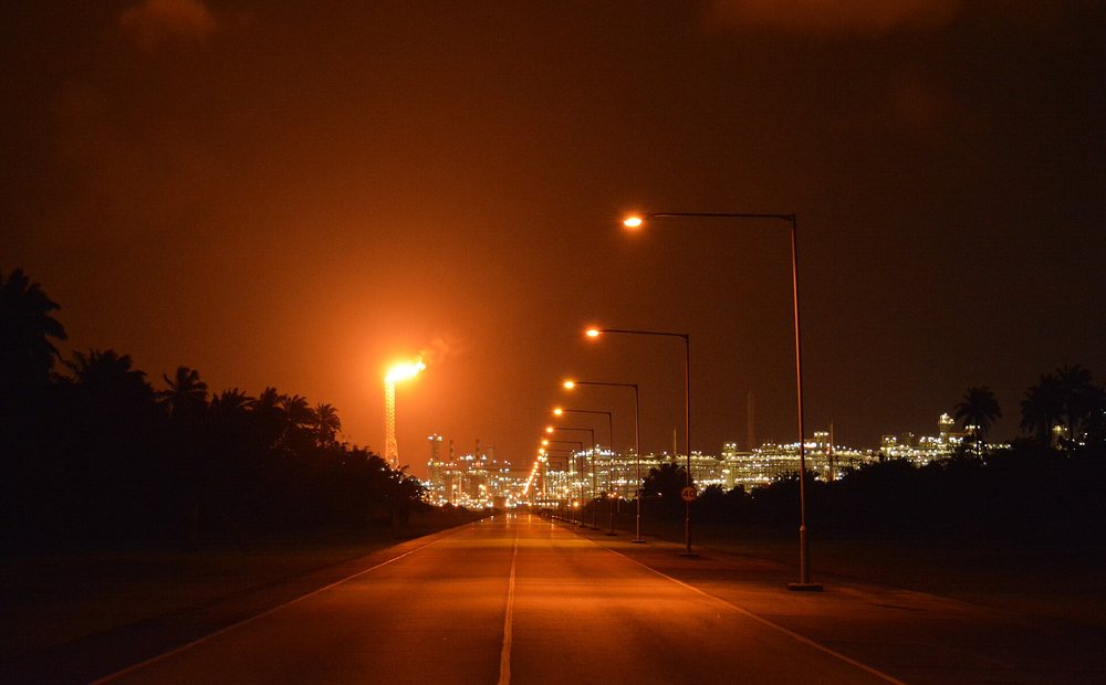 A gas flare glowing over the Nigeria LNG terminal at night