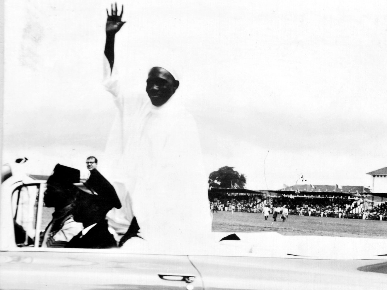 Prime Minister Abubakar Tafawa Balewa waving from an open car at the Independence Day celebrations, 1960